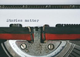 Close-up of a vintage typewriter with the words “Stories matter” typed on paper—symbolizing the power of storytelling in coaching and personal transformation.