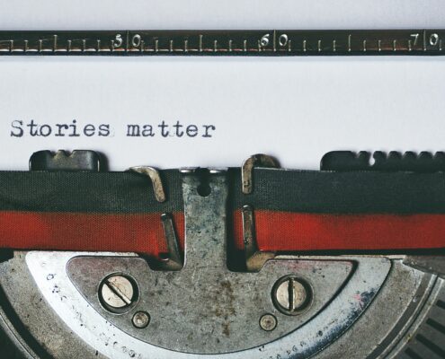 Close-up of a vintage typewriter with the words “Stories matter” typed on paper—symbolizing the power of storytelling in coaching and personal transformation.