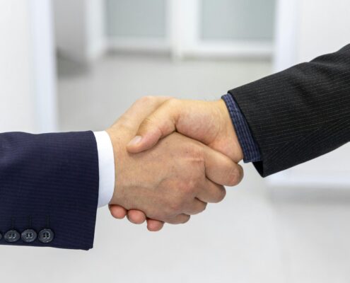 Business handshake representing trust and commitment in a signature coaching program