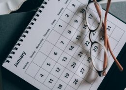 Flat lay of January calendar, red notebook, and planner representing resetting goals and building momentum after January