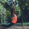 Somatic coaching practice with a woman performing a grounded yoga lunge outdoors, focusing on body awareness, movement, and mind-body connection