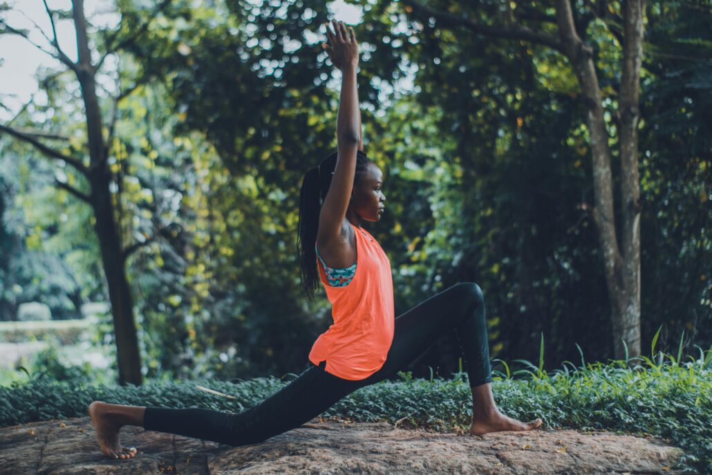 Woman practicing mindful movement in nature demonstrating somatic coaching techniques for body awareness and emotional release