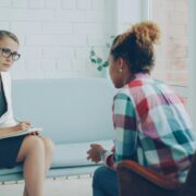 Coach taking notes during a session as conversation shifts beyond goals, illustrating scope creep in coaching