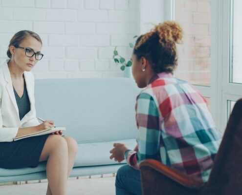 Coach taking notes during a session as conversation shifts beyond goals, illustrating scope creep in coaching