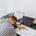 Person experiencing coaching burnout asleep at a desk beside a laptop, financial reports, and work materials, illustrating exhaustion, stress, and overwhelm in a professional coaching environment.