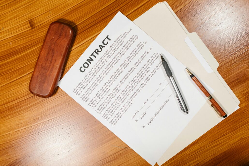 Coaching contract document on a desk with pens and a folder, representing a formal coaching agreement that outlines responsibilities, expectations, confidentiality, and terms of engagement.