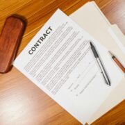 Coaching contract document on a desk with pens and a folder, representing a formal coaching agreement that outlines responsibilities, expectations, confidentiality, and terms of engagement.