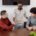 Professional coaching men in a collaborative workplace setting, with three colleagues engaged in discussion and a handshake during a team meeting.