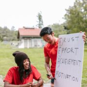 Two coaches discuss trust, effort, achievement, and motivation during an outdoor session focused on coaching high achievers.
