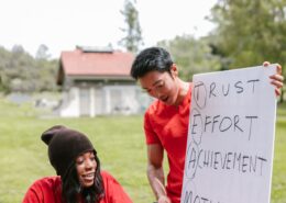 Two coaches discuss trust, effort, achievement, and motivation during an outdoor session focused on coaching high achievers.