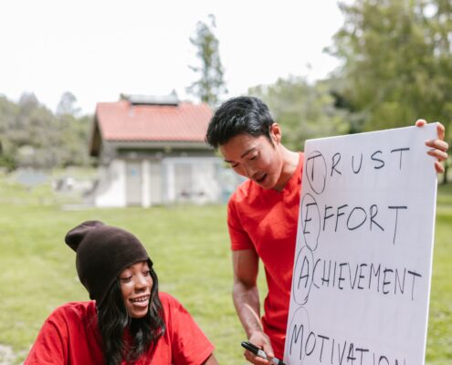 Two coaches discuss trust, effort, achievement, and motivation during an outdoor session focused on coaching high achievers.