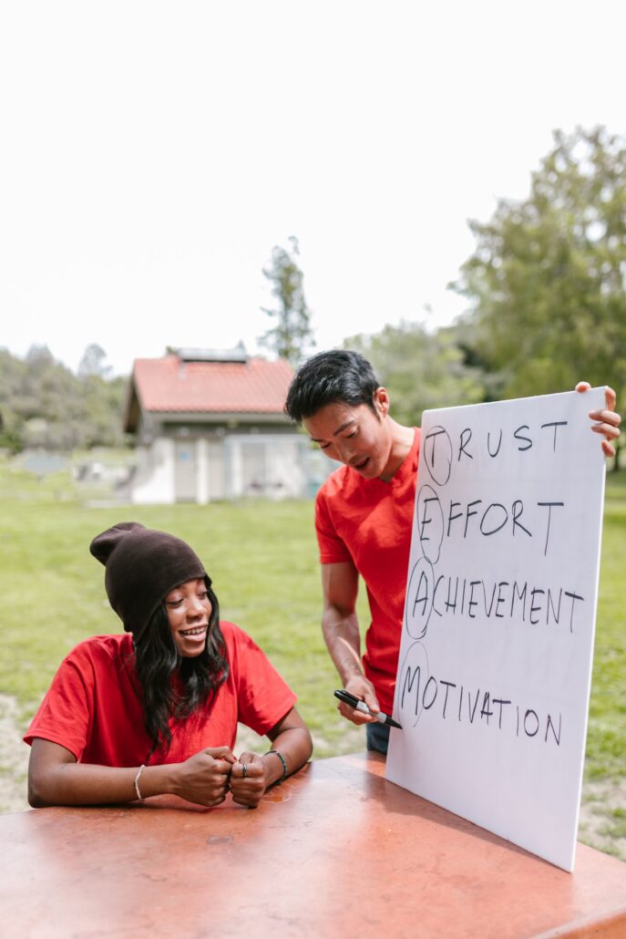Two coaches discuss trust, effort, achievement, and motivation during an outdoor session focused on coaching high achievers.